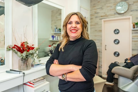 Confident salon owner smiling at camera